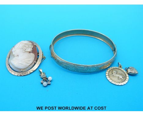 A yellow metal bangle marked 9ct gold, two 9ct gold pendants and a 9ct gold brooch set with a cameo (12.3g)