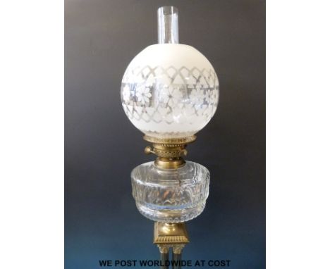 A late 19thC / early 20thC brass oil lamp with globe-shaped shade, supported on four Corinthian columns, marked Rd 355829 (he