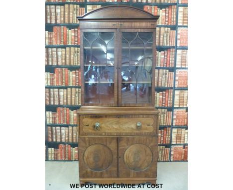 A Georgian flame mahogany secretaire bookcase, the upper section with an arched top and adjustable shelves behind astragal gl