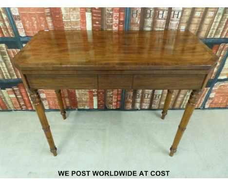 A mahogany and rosewood fold over card table raised on turned legs (H74cm x W89cm x D46cm)