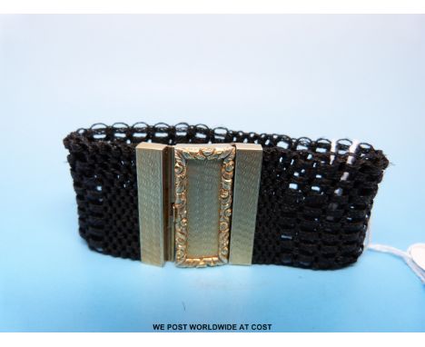 A 19thC plaited hair bracelet, the yellow metal clasp with engine turned decoration 