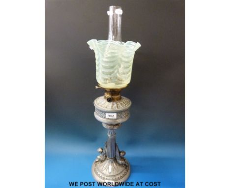 A vintage oil lamp with decorative cast reservoir leading to a fluted column supported by putti with kite mark to base, vasel