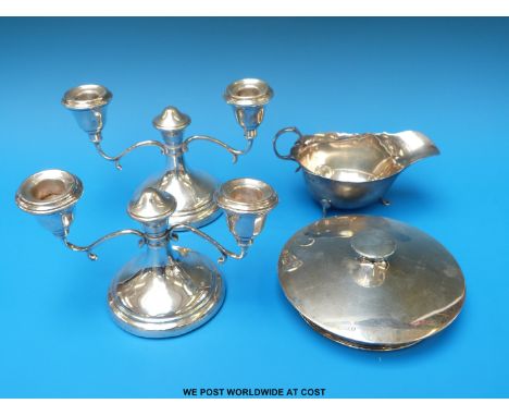 A pair of hallmarked silver candelabra, width 16cm together with a hallmarked silver sauce boat (74g) and a hallmarked silver