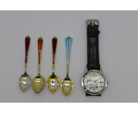 Four silver and enamel spoons and a mechanical skeleton wristwatch
