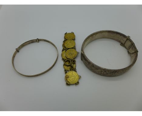 A silver bangle, a coin bracelet and one other bangle