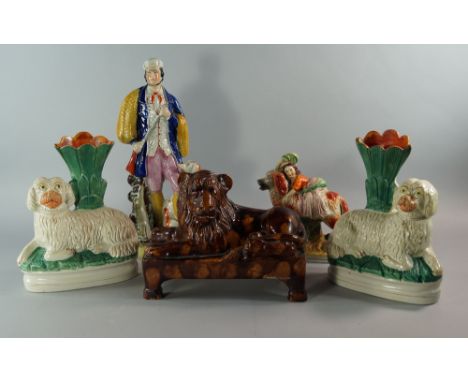 A group of Staffordshire figures, mostly 19th century, to comprise models of a large treacle ware lion modelled on a rectangu