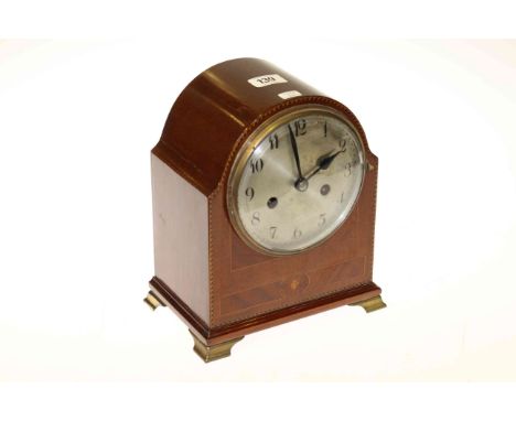 Inlaid mahogany striking mantel clock on brass feet