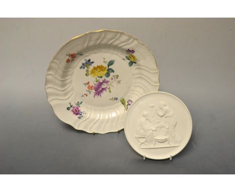 A Meissen plate, painted with flowers, crossed Swords mark; a Royal Copenhagen circular parian panel, printed marks (2)