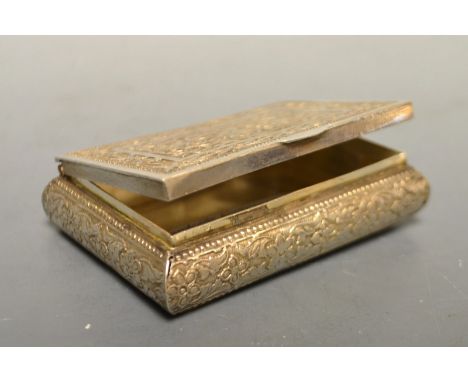 An Indian white metal snuff or tobacco box, probably silver, chased and cast with orchid-type flowers, hinged cover, stamped 
