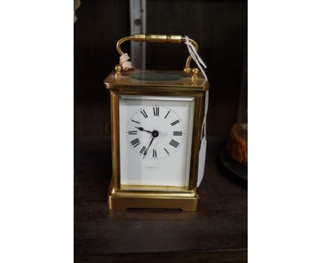 An old brass carriage timepiece,&nbsp;the enamel dial inscribed 'Munsey &amp; Co Ltd', height including handle 14cm.&nbsp; 