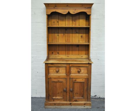 Narrow pine dresser, twin shelf back above two frieze drawers and cupboards, width 92cm, depth 46cm, height 200cm.