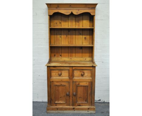 Narrow pine dresser, twin shelf back above two frieze drawers and cupboards, width 92cm, depth 46cm, height 200cm.