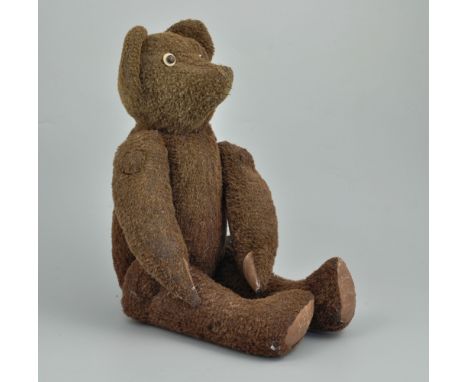 Brown plush teddy bear, early 20th Century, bead eyes and jointed limbs, length 26cms, some re-stitching.