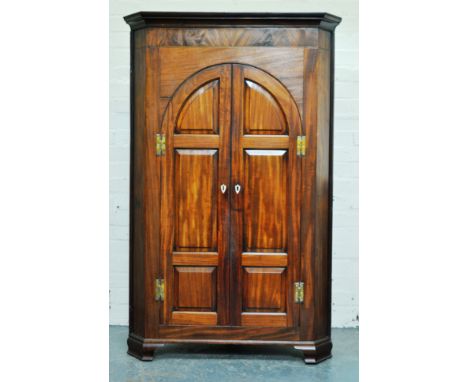 George III mahogany corner cupboard, moulded cornice, plain frieze, arched panel doors with ivory escutcheons, ogee bracket f