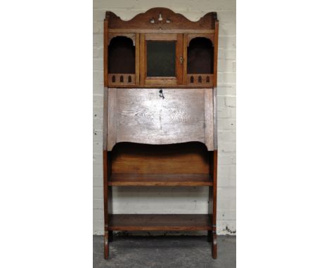 Arts and Crafts oak slim line bureau bookcase, top with three quarter gallery above a glazed cupboard and shelves, fall front