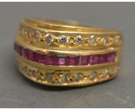 An 18ct Gold Ruby and Diamond Band Ring, with a central band of rubies and two diamond