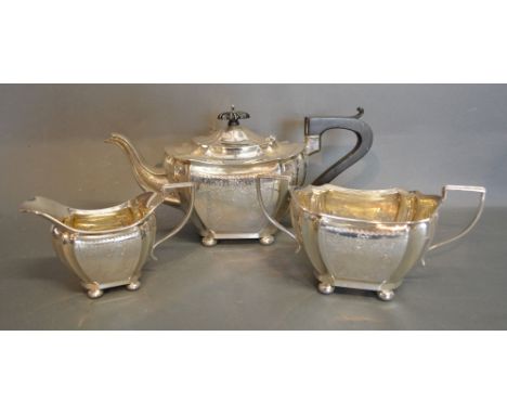 An Edwardian Silver Three Piece Tea Service, comprising teapot, cream jug and two handled sucrier all with engraved decoratio