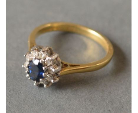 An 18ct Yellow Gold Diamond and Sapphire Cluster Ring, with a central sapphire surrounded by diamonds within a pierced settin