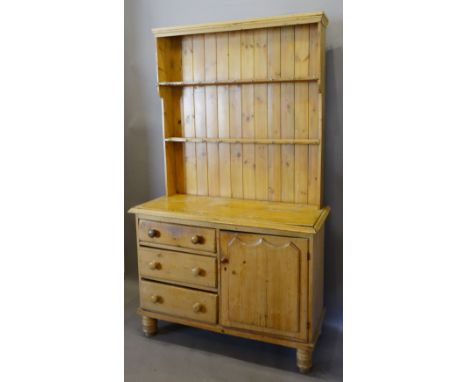 A 19th Century Pine Dresser, the boarded shelf back above three drawers and a cupboard door raised upon low turned feet, 121 