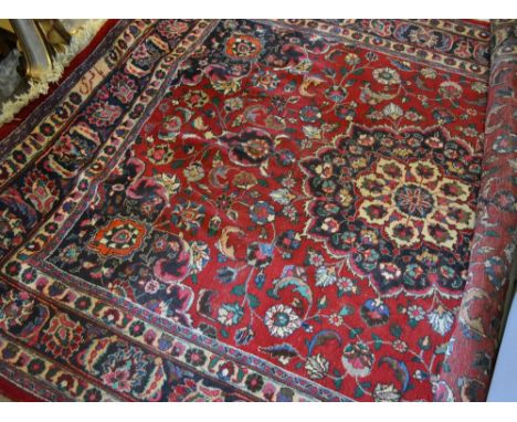 A North West Persian Style Large Woollen Carpet with a central medallion within an all over design upon a red, blue and cream