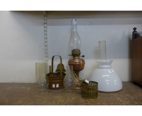 A copper oil lamp, assorted oil lamp chimneys, etc. 