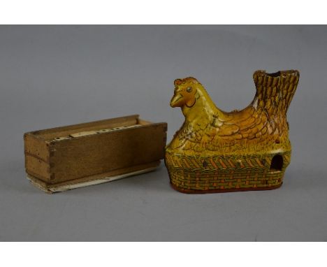 A BALDWIN TINPLATE WIND-UP CHICKEN, yellow lithographed chicken sitting on a basket, wind-up mechanism works and still produc