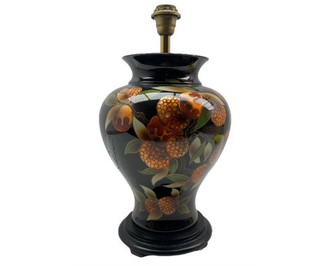 French porcelain table lamp of baluster form decorated with lychees on black ground, on ebonised wooden base H46cm