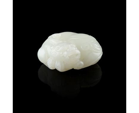 WHITE JADE MYTHICAL BEAST boldly carved in the form of a one-horned mythical beast in a recumbent position with its head turn