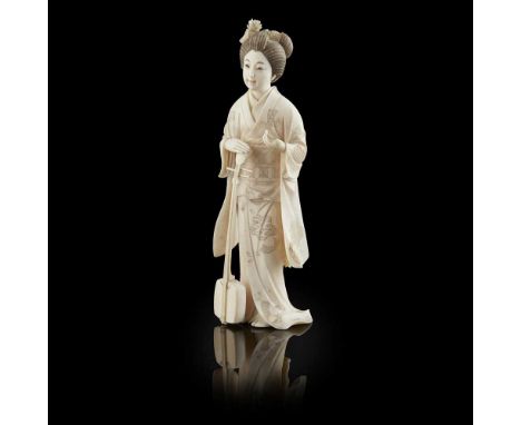 JAPANESE IVORY FEMALE FIGURE OF A SAMISEN PLAYER, MEIJI PERIODthe standing figure dressed in a floral kimono, holding a Samis