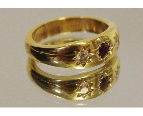 An 18ct gold ring set with central round ruby and flanked by two round diamonds, size M, 7.4g 