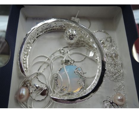 A small selection of white metal jewellery including a bangle, pendants and pair of stud earrings