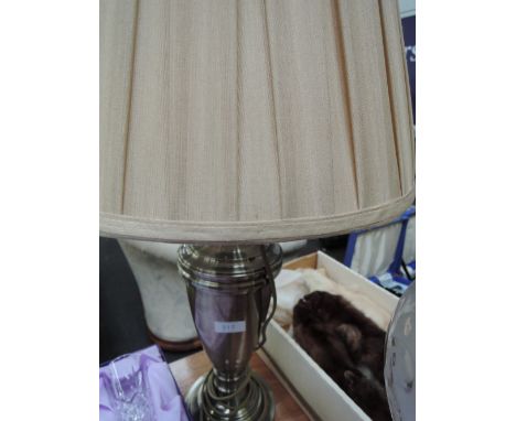 A metal effect table lamp and shade