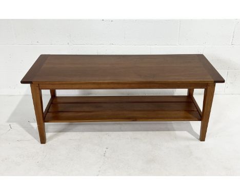 A hard wood coffee table with magazine shelf under 