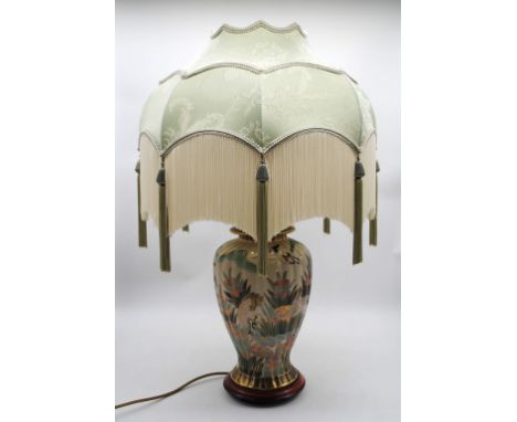 A modern ceramic table lamp, with Oriental decoration and silk shade with long fringing