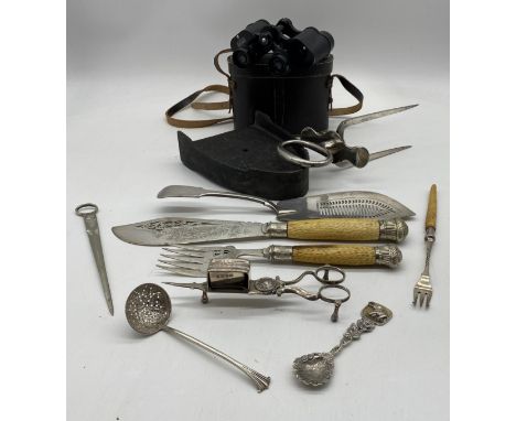 A collection of silver plated cutlery etc, plated meat carving fork, candle snuffer, cast iron trivet and a pair of Aquilus b