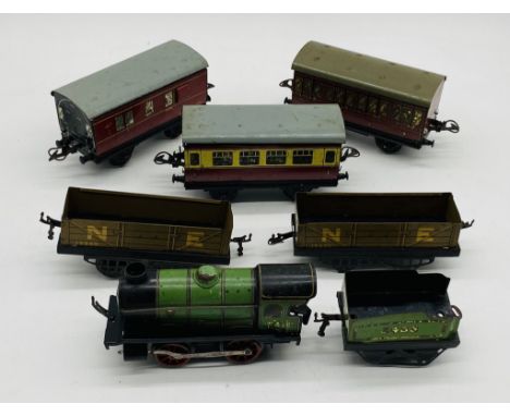 A Hornby Model Railways O gauge tinplate clockwork locomotive with tender in green livery with three passenger coaches and tw