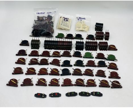 A collection of unboxed Hornby Dublo model railway OO gauge switches in black, maroon and green, along with insulating tabs. 