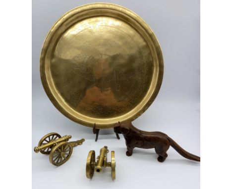 An oriental decorated brass tray, a pair of brass canons and a nutcracker in the form of a dog. 