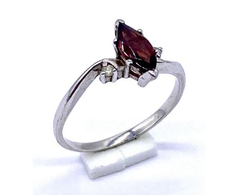 A 10ct white gold ring set with a garnet and diamonds, size M