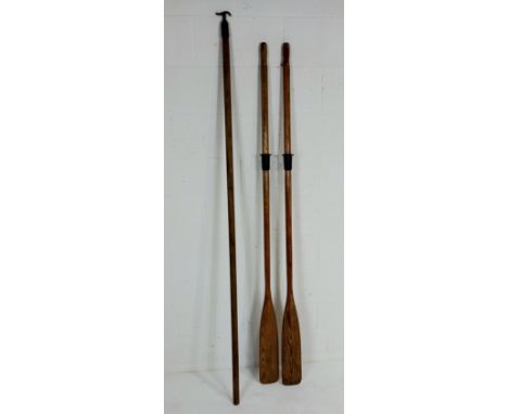 A pair of vintage wooden rowing oars, and a window pole.