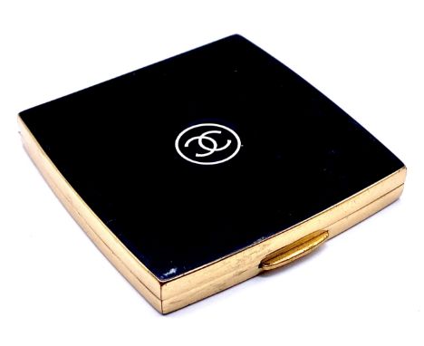 A vintage Chanel powder compact with black lacquered case, the lid centred by interlinking C Chanel logo in white