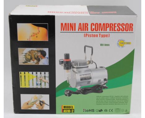 A boxed mini air compressor model AS18-2, with accessories