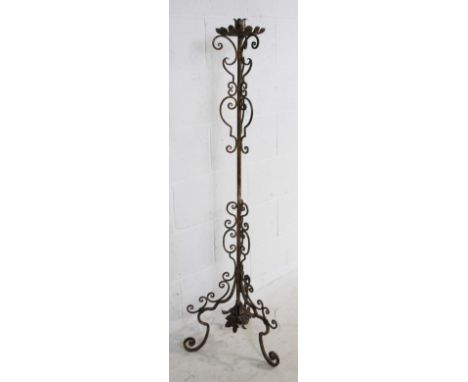 An antique wrought iron floor-standing candlestick - height 135cm