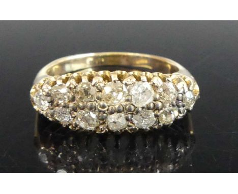 A yellow metal diamond lozenge style dress ring, featuring ten Old European and two later round brilliant cut diamonds in cla