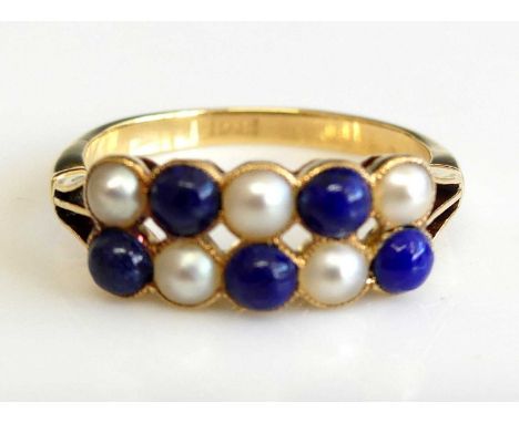 A yellow metal two row half hoop ring with 5 half pearls alternating with 5 round cabochon blue stones in a chequerboard patt