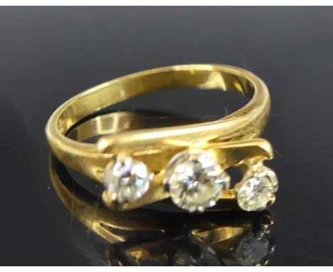 An 18ct gold diamond abstract three-stone ring, comprising three graduated round brilliant cut diamonds in claw settings, wit