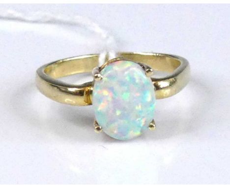 A modern 14ct gold and opal set dress ring, the four-claw set opal cabochon measuring 7.9 x 9.9 x 3.2mm, in a raised setting 