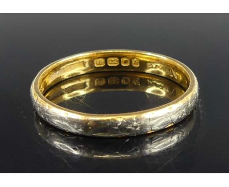A 22ct gold and platinum 2.75mm court shaped wedding ring, with worn floral detail engraved around the edge, size Q½, gross w