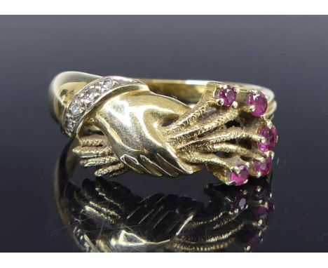 A 14ct gold, ruby and diamond set dress ring, arranged as a hand with a bouquet of flowers, the flower heads as five round cu