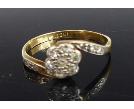 A yellow and white metal diamond crossover style floral cluster ring, featuring seven Old European and five rose cut diamonds